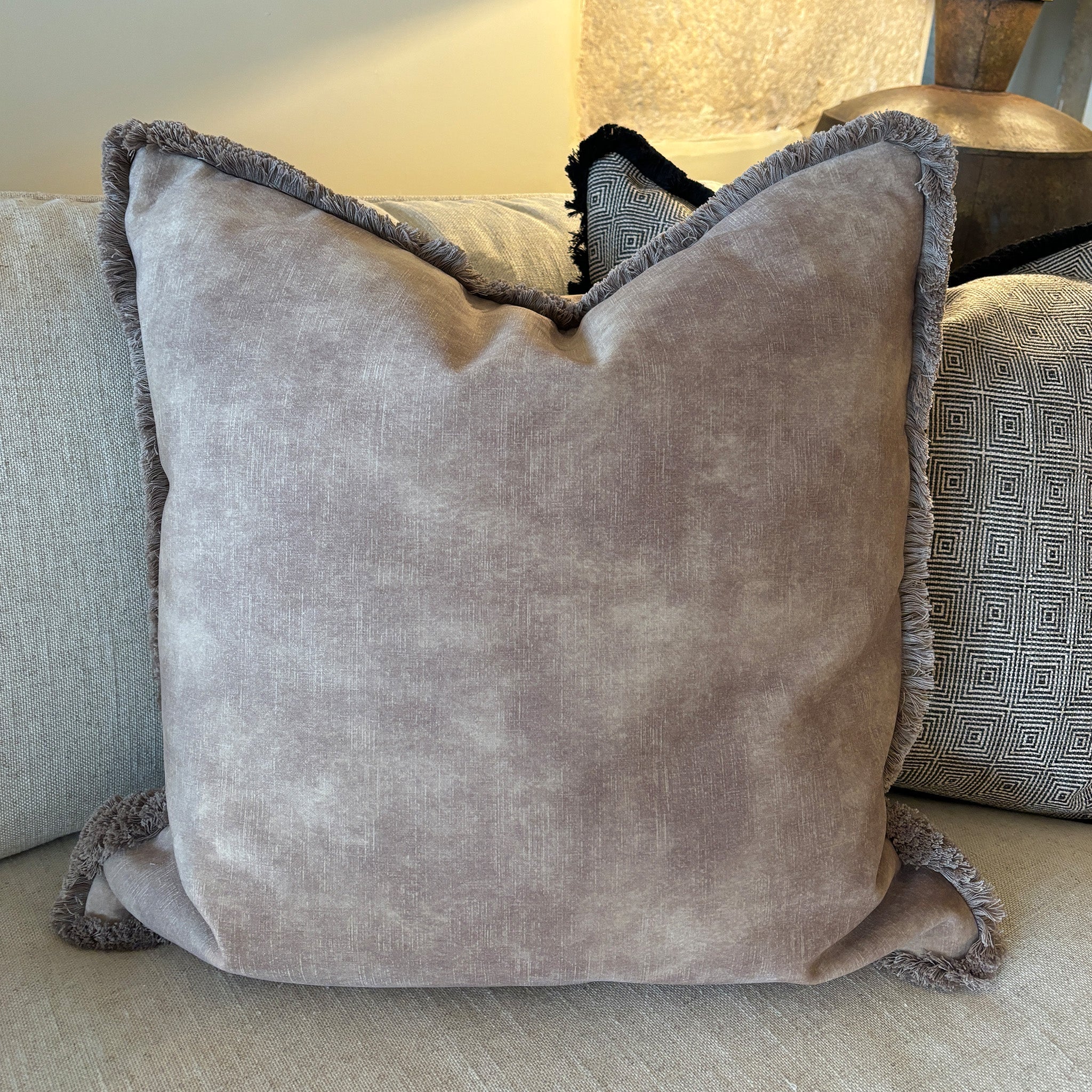 Luxury velvet and fringed cushion in mocha taupe. The fabric has a textured effect look but is a beautiful smooth finished fabric. Pictured with our taupe colourfed fringe, also available in our carefully selected piping colours, and alternative fringe colours. A plump feather inner cushion is included. Our luxury made to order cushions are plump and cosy. Available sizes in cm: Square: 45 x 45 / 50 x 50 / 60 x 60 Rectangular: 30 x 48 / 30 x 56 / 35 x 56 Made to order in approx 3 weeks